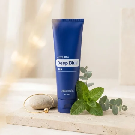 doTERRA Deep Blue Rub Lindernde Muskellotion Tube auf einem hellen Naturstein-Hintergrund mit Minzblättern bei fairschenkt