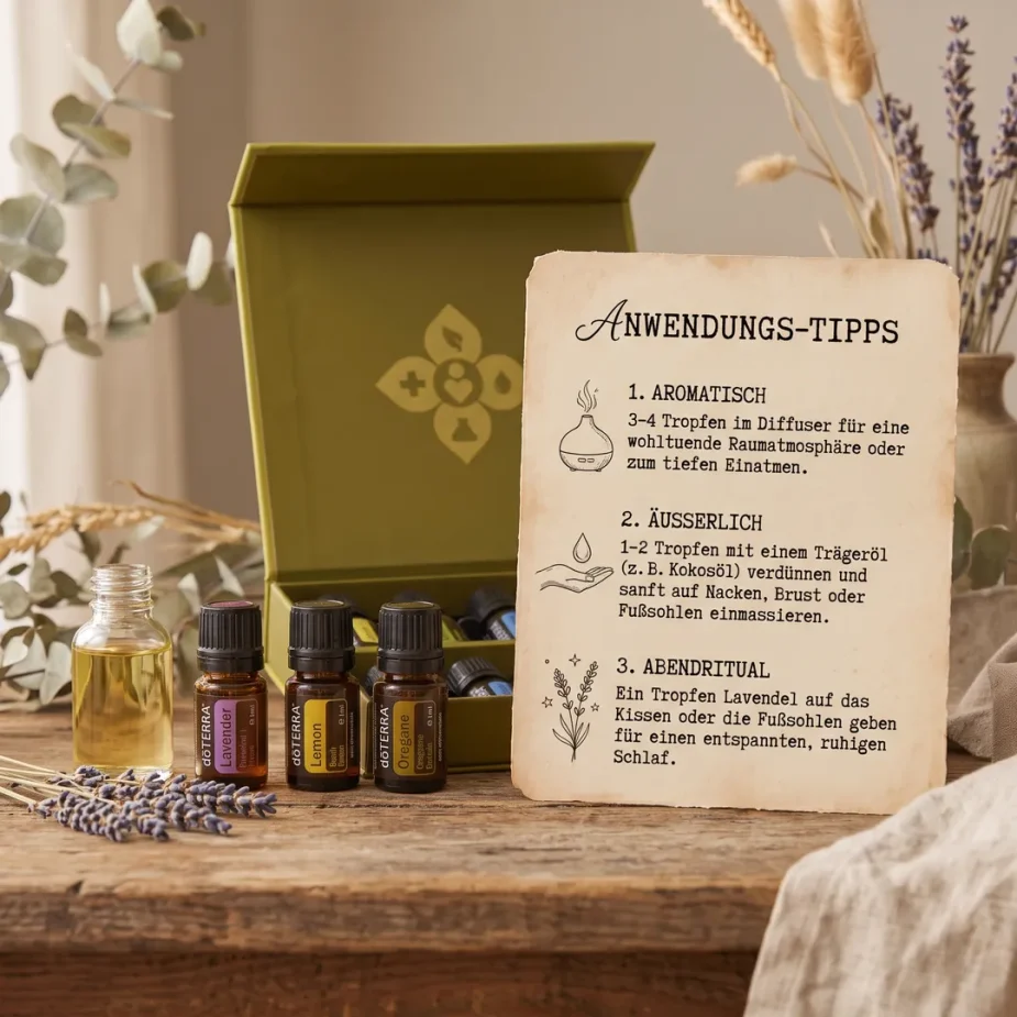 Ätherische Öle Starter-Set – doTERRA Family Essentials Kit (10-teilige Hausapotheke) Deine Infokarte mit Alltagstipps zur Anwendung von ätherischen Ölen (Aromatisch, Äußerlich und Abendritual) neben Fläschchen und dem geöffneten doTERRA Family Essentials Kit Starter-Set auf einem Holztisch.