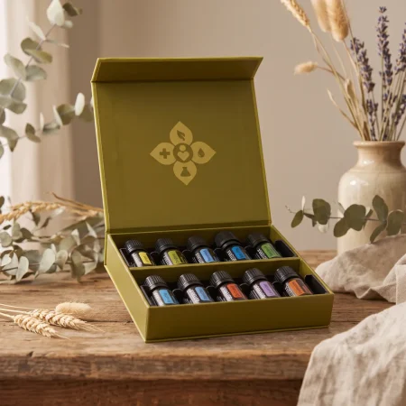 aetherische-oele-starter-set-doterra-family-essentials-kit-geoeffnet Das geöffnete doTERRA Family Essentials Kit (ätherische Öle Starter-Set) auf einem rustikalen Vintage-Holztisch, das die 10 sortierten Ölfläschchen in ihren Fächern und das goldene Logo im Deckel zeigt.